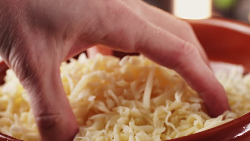Grated pizza cheese mozarella close up, chef hand touching cheese for Italian pasta or pizza. Macro close up of cheddar cheese. Royalty-Free Stock Footage #1099732619