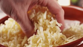 Grated pizza cheese mozarella close up, chef hand touching cheese for Italian pasta or pizza. Macro close up of cheddar cheese. - Powered by Shutterstock - Get 15% off with code: PIKWIZARD15