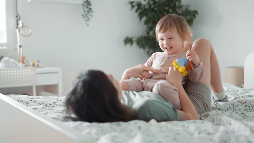 close up of young happy smiling asian mother play laugh with her curly toddler son baby in morning bedroom. Concept of children, baby, parenthood, childhood, life, maternity, motherhood relationship Royalty-Free Stock Footage #1099733179