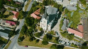 Aerial drone video of a church in a Hungarian city within the European Union with mountains and the city in the background.