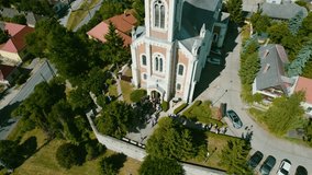 Aerial drone video of a Christian church in the background with the town of Tatabánya and mountins, a small town within the European Union and within Hungary.
