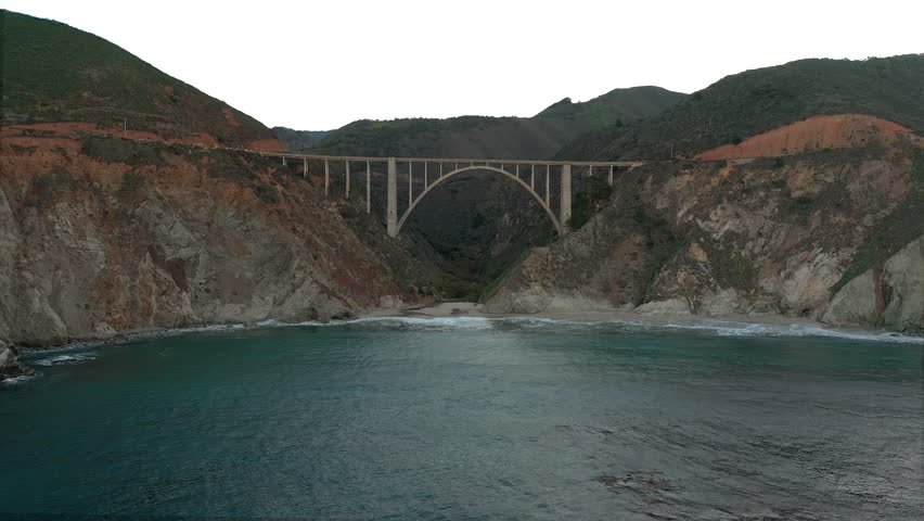Bixby Bridge in Big Sur as seen from the ocean. Slow drone forward motion.