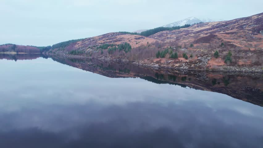 Loch Lochy Łąkę in Scotland. Mirror reflection of mountains and clouds. Drone flight low to water surface. 