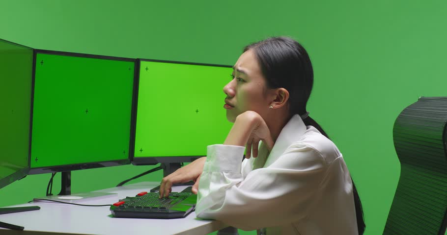 Side View Of Tired Asian Woman Yawning While Working With Mock Up Multiple Computer Monitor In Green Screen Studio
 | Shutterstock HD Video #1099738473