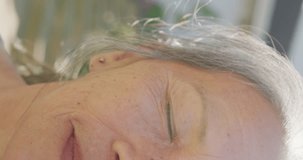 Vertical video of portrait of happy asian senior woman on sunny day in garden. Active retirement and lifestyle concept.