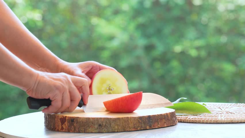 Gardeners sliced Fresh Honey core Apple over blur greenery background, Red Honey core Apple over green natural Blur background. | Shutterstock HD Video #1099739863