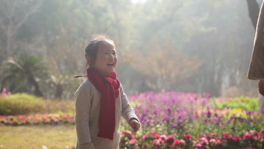 lovely asian little girl smile laugh in the park during chines new year wear red scarf