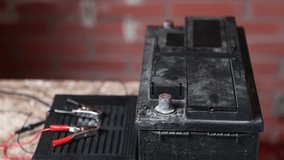  Alligator clips of charger are connected to car battery.