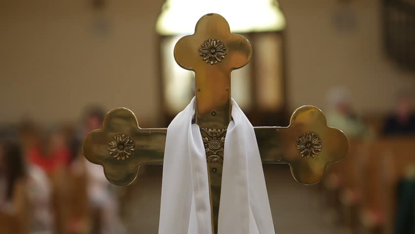 Orthodox metal cross in the church, parishioners are walking in the background. | Shutterstock HD Video #1099754809