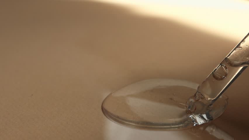 Hyaluronic acid close-up on a beige background with a glass dropper. Body care product, transparent cosmetic texture. | Shutterstock HD Video #1099754859