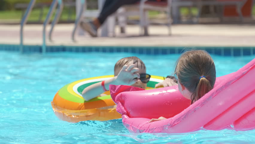 Young child girl relaxing on summer sun swimming on inflatable air mattress in swimming pool during tropical vacations. Summertime activities concept Royalty-Free Stock Footage #1099756469