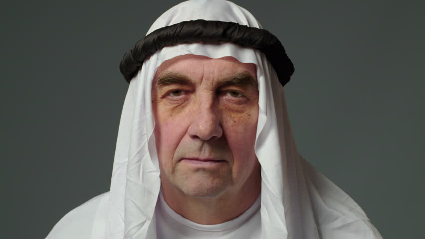 Elderly man with united arab emirates traditional clothes posing in a studio. Beautiful islamic portrait of portrait arab businessman kandur. Studio footage with different poses