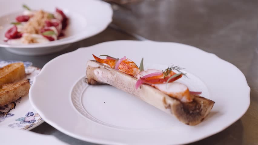 Close-up panning shot of a beautifully decorated dinner plate with a course prepared on a bone | Shutterstock HD Video #1099757529