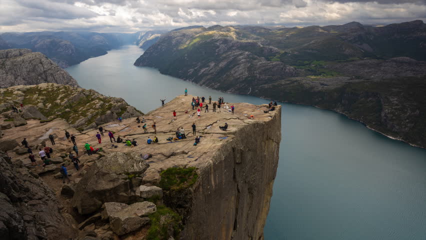People enjoying the amazing view from the spectacular Preikestolen (Pulpit Rock) in Lysefjorden, Norway Royalty-Free Stock Footage #1099758027