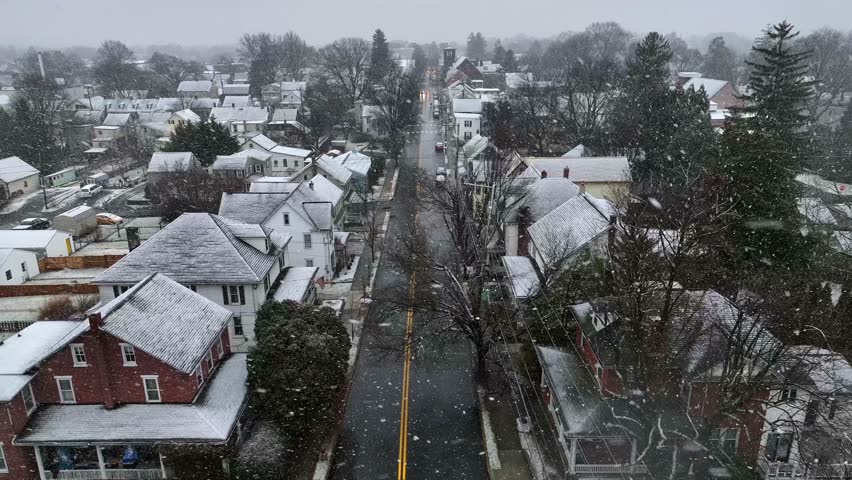 Snow storm over American small town. Aerial drone shot of houses and building accumulating snow on winter day in Pennsylvania. | Shutterstock HD Video #1099758335