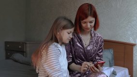 a young mother holding a smartphone in her hand shows her daughter social networks, makes an online purchase, orders food. A mother teaches her daughter how to use a smartphone
 - Powered by Shutterstock - Get 15% off with code: PIKWIZARD15