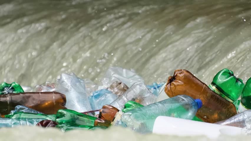Plastic bottles in the river close up. The problem of human impact on the environment | Shutterstock HD Video #1099762727