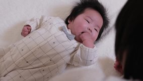 Video of a mother stroking her infant's cheeks to lull her to sleep