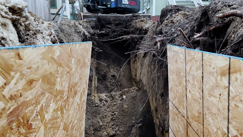 A bucket of the excavator getting soil from the ground during the winter time. Close up shot footage