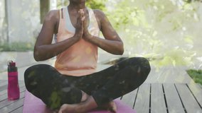Animation of trees over african american woman doing yoga, meditating, slow motion. Sport, fitness and healthcare concept digitally generated video.