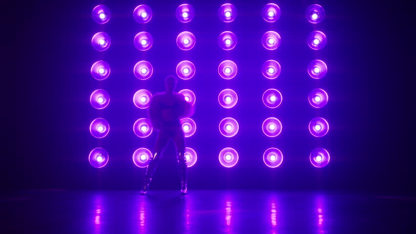 Slim fit active woman dancing RnB style moves, spinning on floor, performing choreography for show on stage. Female silhouette in stylish show outfit costume fluffy pink fur coat, shiny silver boots 