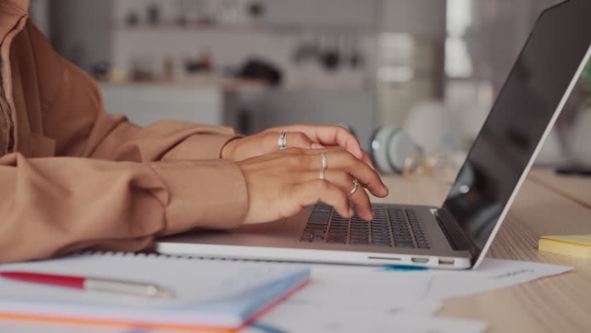 Two hands freelancer woman typing article on laptop keyboard remotely completing assignment for company manager or creating resume to search for job and get good offer sits at table with papers | Shutterstock HD Video #1099782549