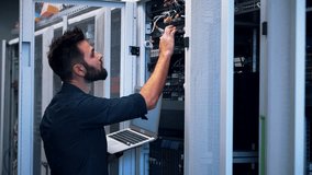 System Engineer Control Room IT Administrator. Server Engineer Work On Laptop in Data Center. Male Server IT Engineer Work Data Center. Man Work In Server Room. Male Typing On Laptop In Server Room - Powered by Shutterstock - Get 15% off with code: PIKWIZARD15