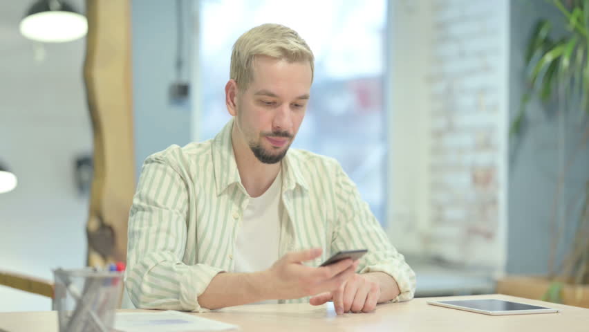 Young Man Talking on Phone in Anger