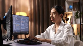 Asian Woman Programmer Thinking About Something And Raising Her Index Finger While Creating Software Engineer Developing App, Program, Video Game On Desktop Computer At Home
