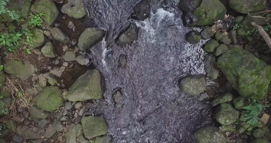 Rushing creek on Nuuanu Trail by Ginger Pond in Hawaii Kai east Honolulu, aerial top down dolly