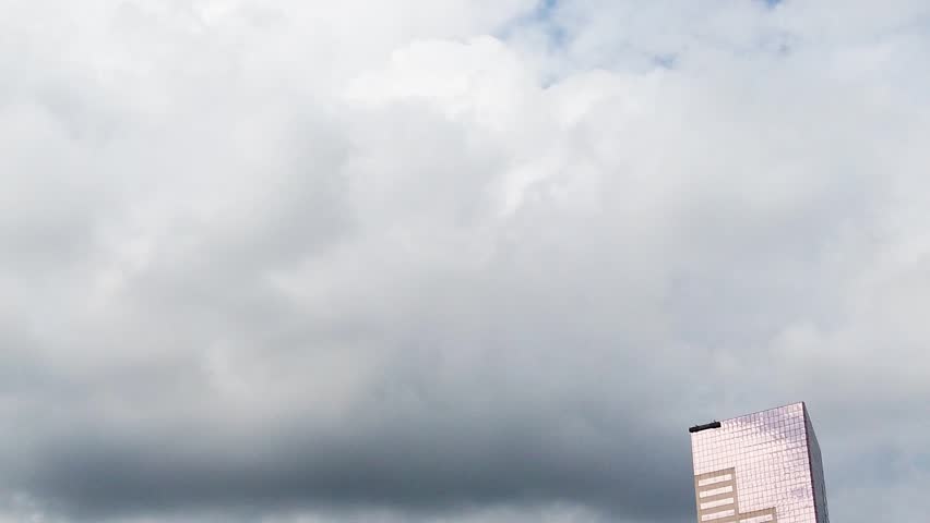 HD Pan left to right past Big Pink skyscraper to the Portland Oregon Old Town sign in left center frame with Old Town water tower peeking through and out from sign with mostly cloudy sky.