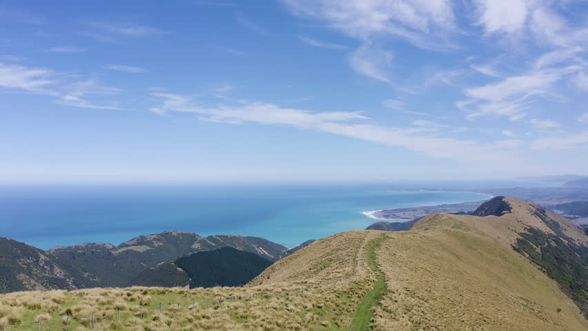 Aerial flowing thru the rolling Hills and Mountains of New Zealand overlook the stunning beaches in Kiakoura.