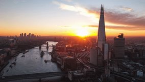 Establishing Aerial View Shot of London UK, United Kingdom, Pull back, sun rising over cit, Thames river, tower bridge