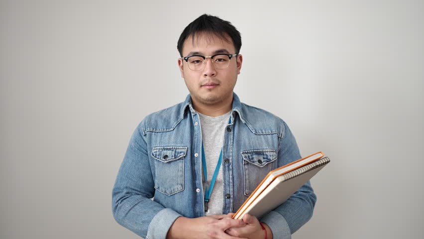Young chinese man smiling confident holding books over isolated white background