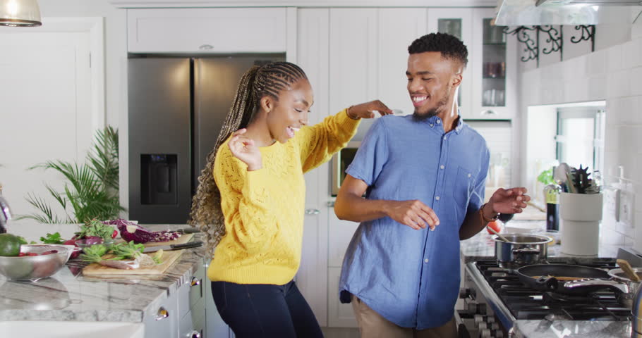 Happy african american couple dancing in kitchen. Lifestyle, relationship, fun, spending free time together concept. | Shutterstock HD Video #1099804345