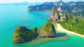 Drones are flying over the tropical sea coast, green limestone mountains. Krabi, One of the most beautiful places to visit in Thailand. Beautiful tropical sea in asia. Natural sea background video
