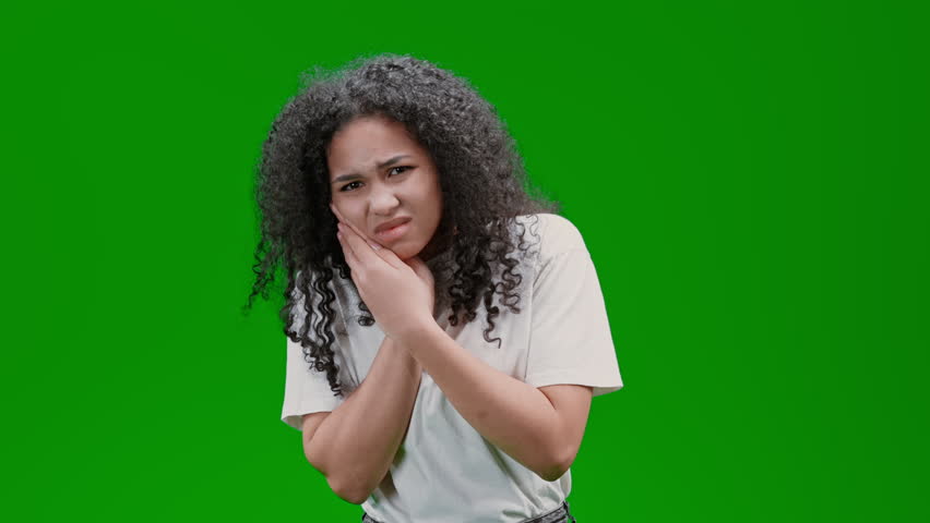 Woman with curly long hair dressed white shirt suffering from toothache Isolated on Green Screen | Shutterstock HD Video #1099815787
