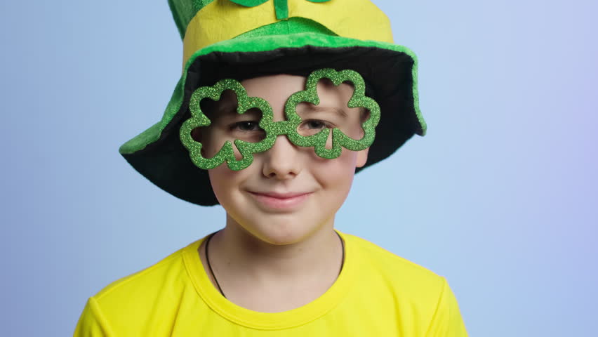 St Patricks day celebration concept. Boy having fun wearing clover shaped eyeglasses. 
