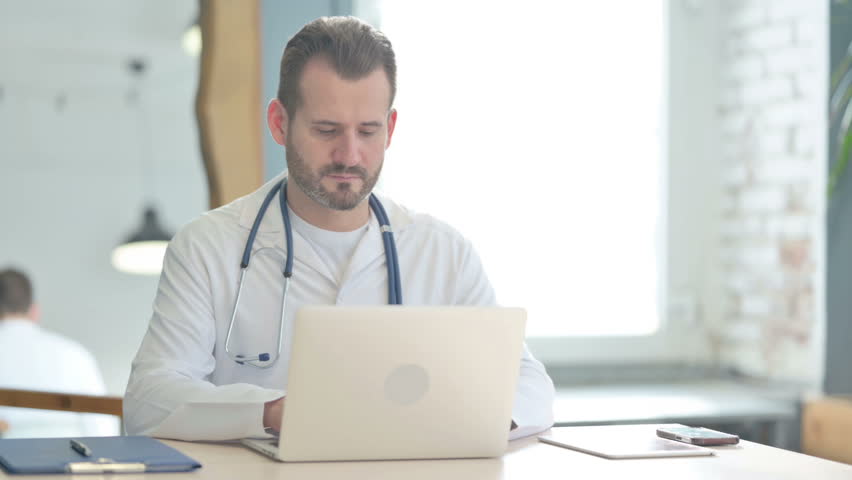 Doctor Looking at Camera at Work in Clinic