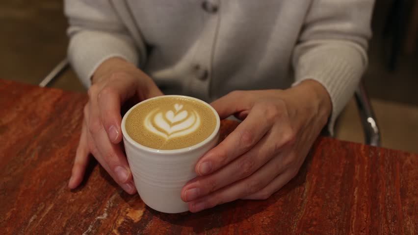 Close-up of a cup of coffee and women