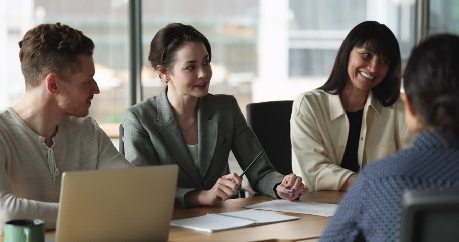 Young Caucasian company CEO woman talking to employees on office meeting, telling project strategy, explaining ideas. Positive diverse team workers listening to speaking female leader Royalty-Free Stock Footage #1099822929