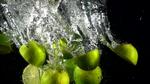 Стоковое видео: Super slow motion of falling lime, for tequila cocktail into splashing water. Lemonade cooking concept. Filmed on high speed cinema camera, 4k 1000 fps.