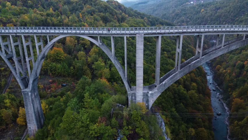 Djurdjevic Bridge, Montenegro. Beautiful autumn landscape. Golden Autumn. Drone video. Lots of trees and greenery. Attraction of Montenegro. Beautiful landscape. A long bridge. Art of architecture. 
