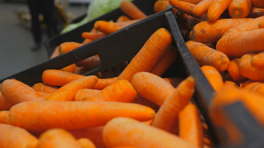 Carrots in boxes on the counter in the supermarket in the vegetable department | Shutterstock HD Video #1099828327