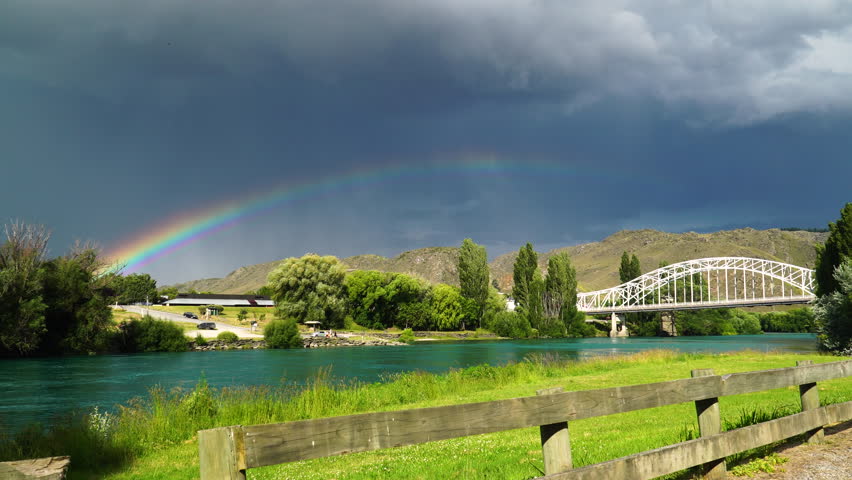 Historical bridge, Alexandra, New Zealand with storm clouds and rainbow