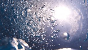 Underwater slow motion video of deep blue air bubbles released in jacuzzi spa creating perfect relaxing treatment for well being