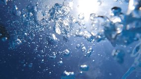 Underwater slow motion video of deep blue air bubbles released in jacuzzi spa creating perfect relaxing treatment for well being