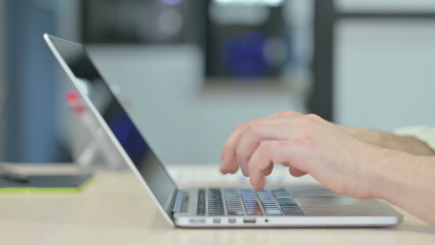 Side View of Man Typing on Laptop