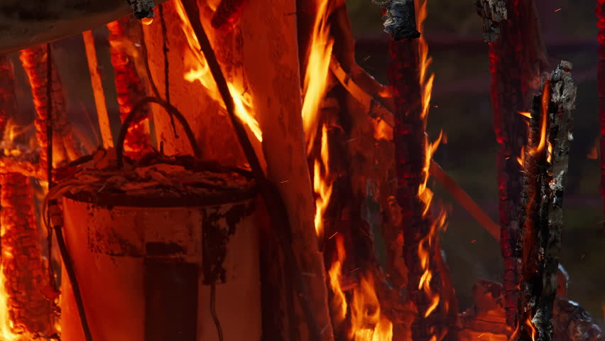 Small home engulfed in flames with a large fire. Footage of large flames. Fire and smoke billowing out of a trailer home.