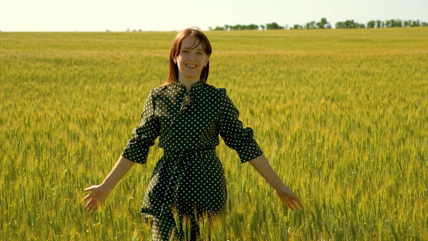 Free young woman go across field, touching ears of wheat with her hand. Girl enjoys nature under warm sun in wheat field. Young woman farmer touches ears of wheat with her hand in field. Happy girl | Shutterstock HD Video #1099839309
